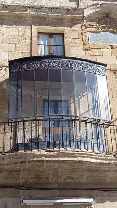 an old building with a round window and wrought iron balconies on the second floor