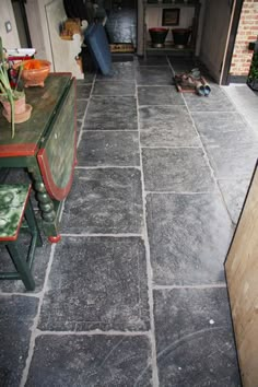 an outdoor kitchen and dining area with stone flooring