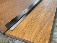 a close up of a wooden table with a metal strip on it