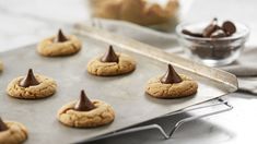 cookies with chocolate on top are sitting on a cookie sheet and ready to be baked