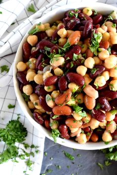 a white bowl filled with beans and parsley