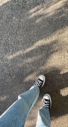 a person standing in the street with their feet up and one foot on his skateboard