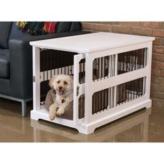 a dog is laying down in a pet crate on the floor next to a couch