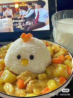 a plate with rice and chicken in it next to a glass of milk on a table