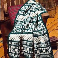 a green and white blanket sitting on top of a wooden chair