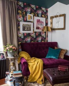 a living room filled with furniture and wallpaper covered in colorful floral prints on the walls