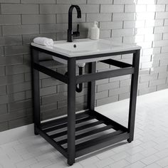 a white sink sitting on top of a black stand next to a brick wall in a bathroom