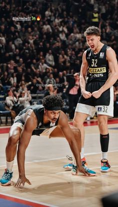 two basketball players are on the court with their feet in the air and one is looking down