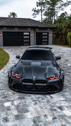 a black sports car parked in front of a house