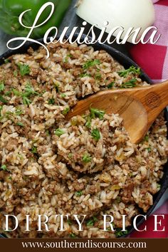 a close up of rice in a pan with a wooden spoon