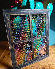 an old window is decorated with colorful beads