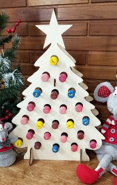 a christmas tree made out of wooden pegs next to two stuffed animals and a toy mouse