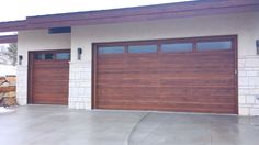 two brown garage doors in front of a house