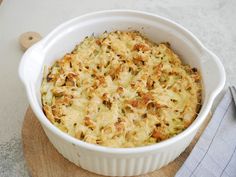 a casserole dish is sitting on a cutting board