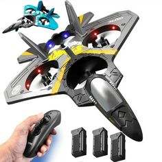 a hand holding a remote control toy with four different types of planes in the background