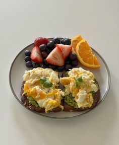 an open face sandwich with eggs, fruit and yogurt sits on a plate