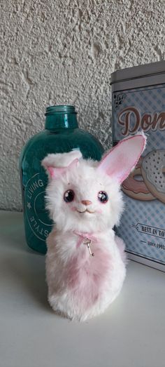 a white stuffed animal sitting next to a box