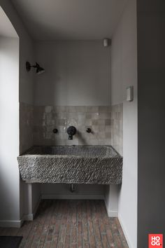 a bathroom sink sitting next to a wall mounted faucet in front of a window