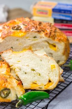 a loaf of bread sitting on top of a cooling rack next to some green peppers