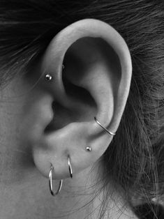 a close up of a person's ear with two piercings