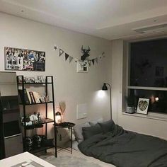 a bed room with a neatly made bed next to a window and a book shelf