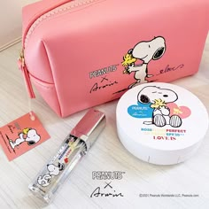 a pink bag with peanuts on it next to a white container and some other items