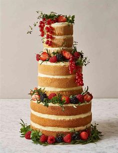 a three tiered cake with strawberries and berries on top