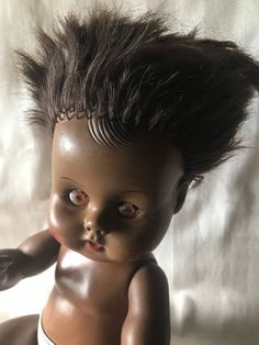 an old doll with black hair on it's head