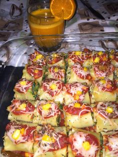 a tray filled with lots of food next to an orange and some glasses on the table