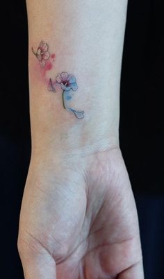 a woman's wrist tattoo with flowers on it