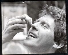 black and white photograph of a man eating something