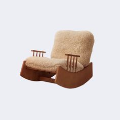 a wooden rocking chair with sheepskin on the back and seat cushion, in front of a white background