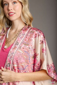 The Satin Breeze Border Print Kimono is an elegant and lightweight layering piece that adds a touch of sophistication to any outfit. Crafted from 100% polyester, this kimono features a smooth, silky satin finish that drapes beautifully over the body. The open front design allows for effortless styling, while the intricate border print adds a touch of artistry and visual interest. Short sleeves make it perfect for warmer weather, and the flowy silhouette enhances its relaxed, bohemian vibe. Fit & Spring Paisley Print Open Front Kimono, Spring Satin Wrap Kimono, Spring Open Front Paisley Print Kimono, Elegant Wrap Kimono With Floral Print, Elegant Floral Print V-neck Kimono, Elegant Open Front Kimono For Spring, Chic Satin Wrap Kimono, Elegant Satin Beach Kimono, Elegant Beach Satin Kimono