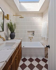 a bathroom with a checkered floor and skylight above the bathtub is shown