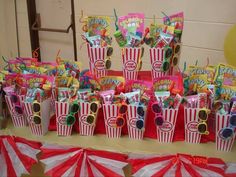 a table topped with popcorn buckets filled with candy