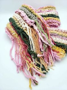 multicolored crocheted scarf laying on top of each other with fringes