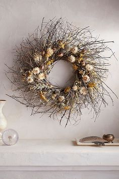 a wreath is hanging on the wall above a mantle