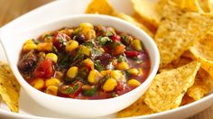 a white bowl filled with corn salsa and tortilla chips