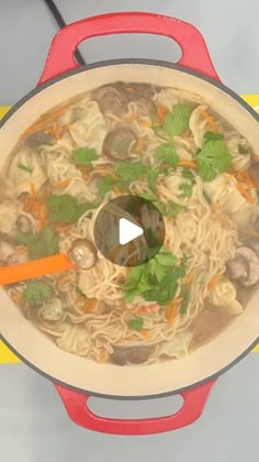 a pot filled with noodles and vegetables on top of a table