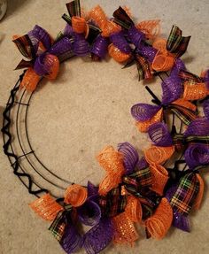 a wreath with orange and purple bows on it