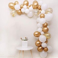 gold and white balloons are arranged in the shape of an o'letter on a wall