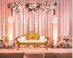 an elaborately decorated stage set up for a wedding ceremony with flowers and greenery