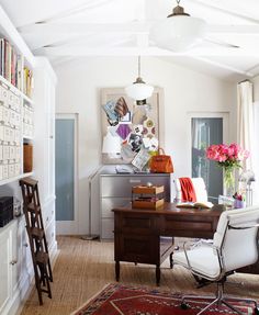 a room with a desk, chair and bookshelf on the wall in it