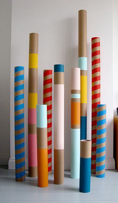 a group of different colored poles in a room with white walls and flooring on the ground