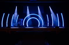 the stage is lit up with bright blue lights and round objects on it's sides