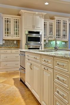 a large kitchen with white cabinets and marble counter tops is featured on the appliance page