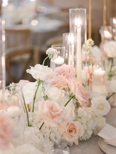 a table topped with lots of white and pink flowers