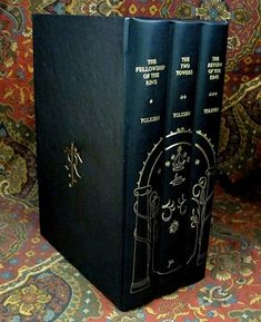 two black books sitting on top of a colorful carpet