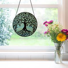 a vase filled with flowers sitting next to a window sill on top of a counter