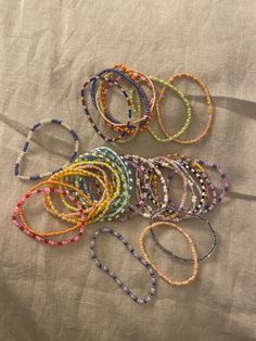 several bracelets are laid out on top of each other, with different colored beads